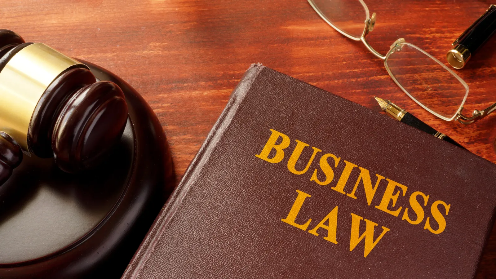 Gavel, glasses, and book titled "Business Law"
