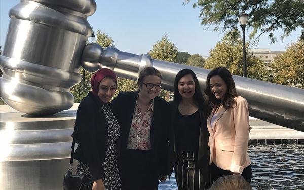Pre-Law students pose in front of a gavel statue