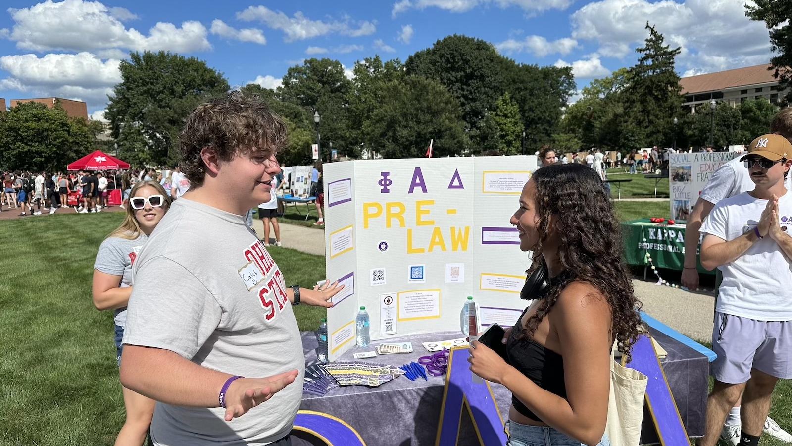 Two students talking in front of a display poster